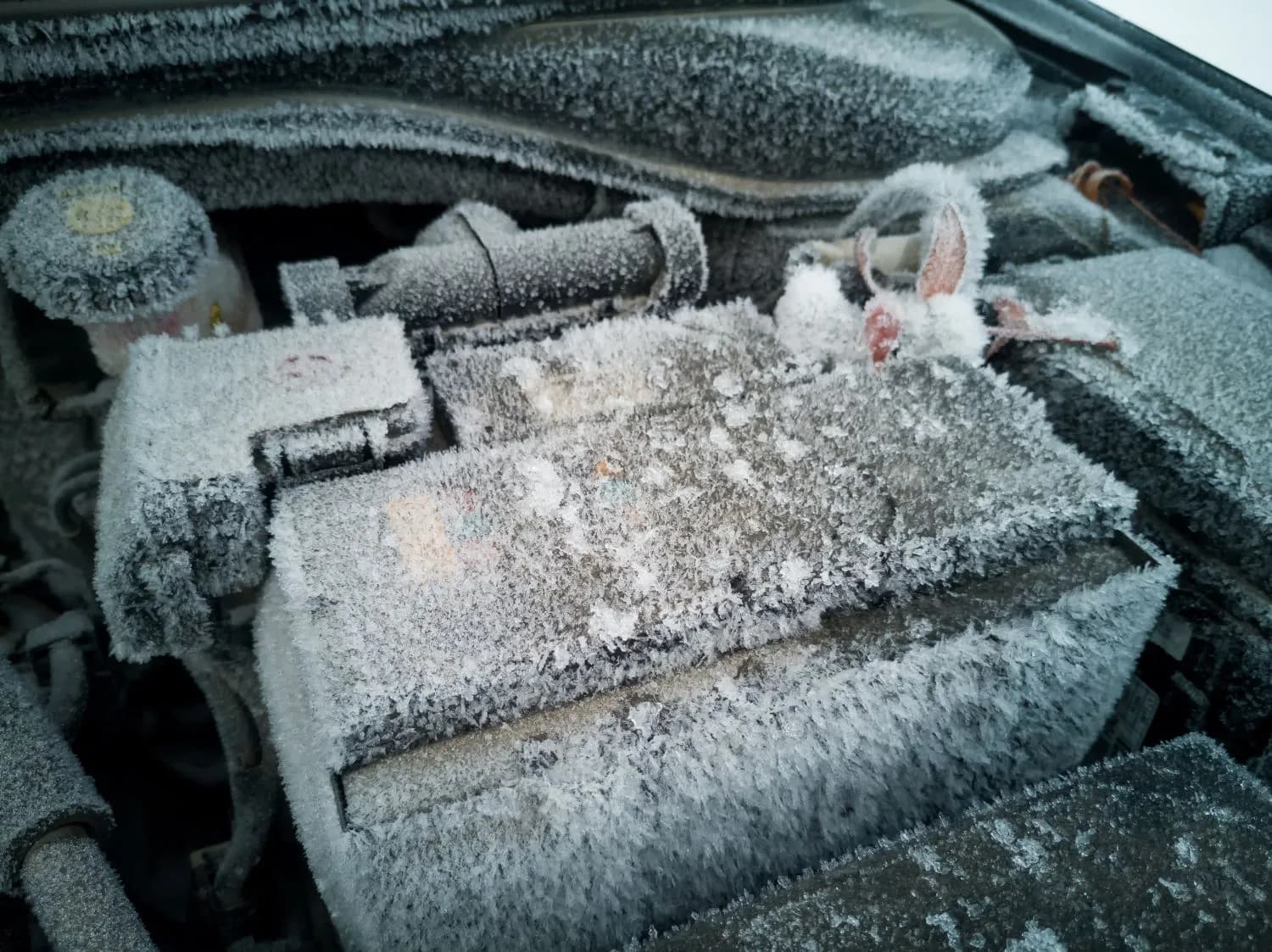 Frost-covered engine bay and battery
