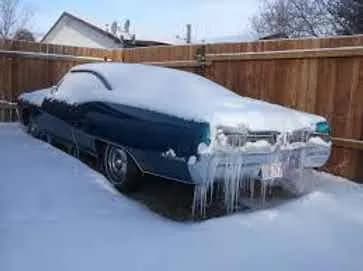 Classic car covered in snow and icicles