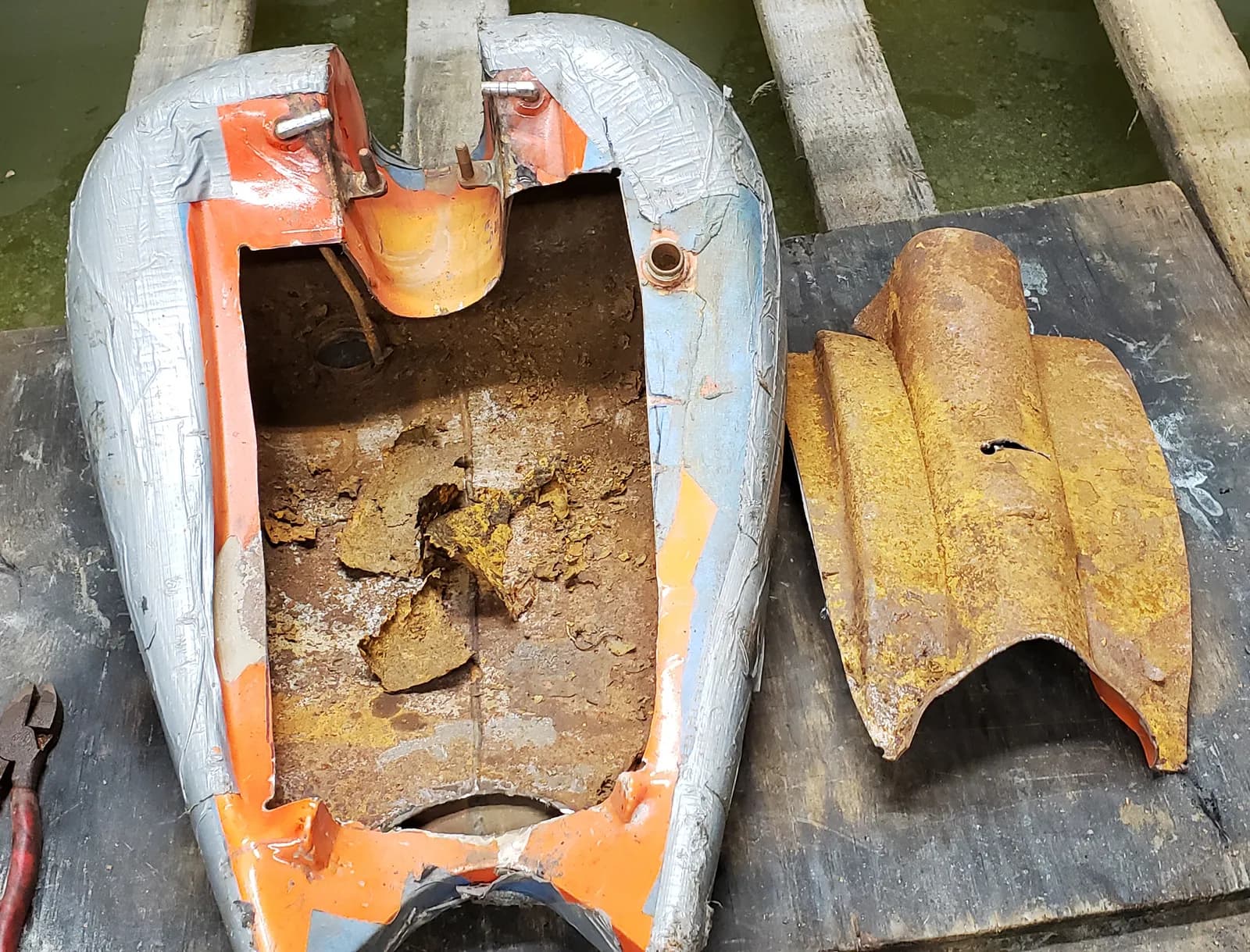 Motorcycle tank cut open to clean out layers of rust